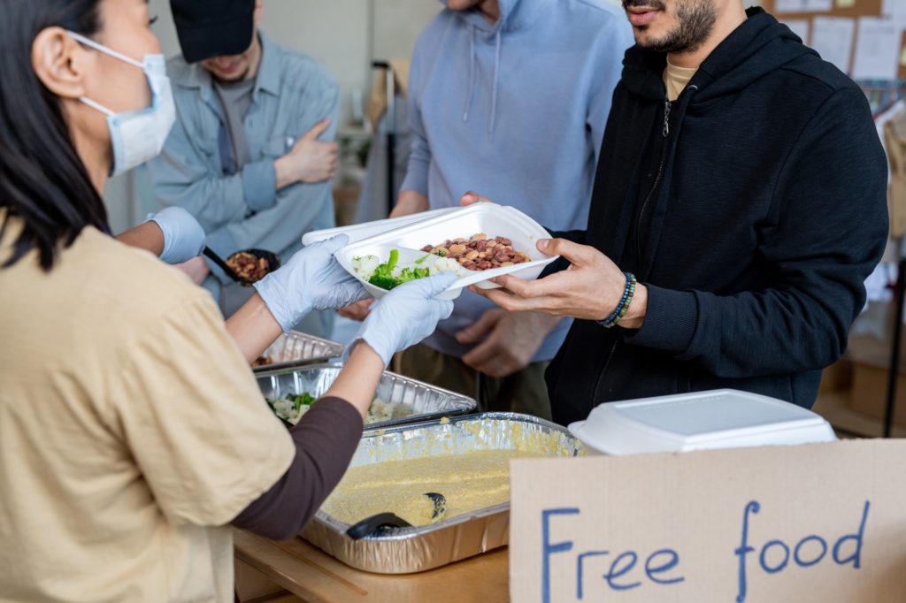 Volunteers serving free food to refugees or homeless people